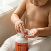 Infant applying Amra Baby fragrance free baby body lotion to their hands